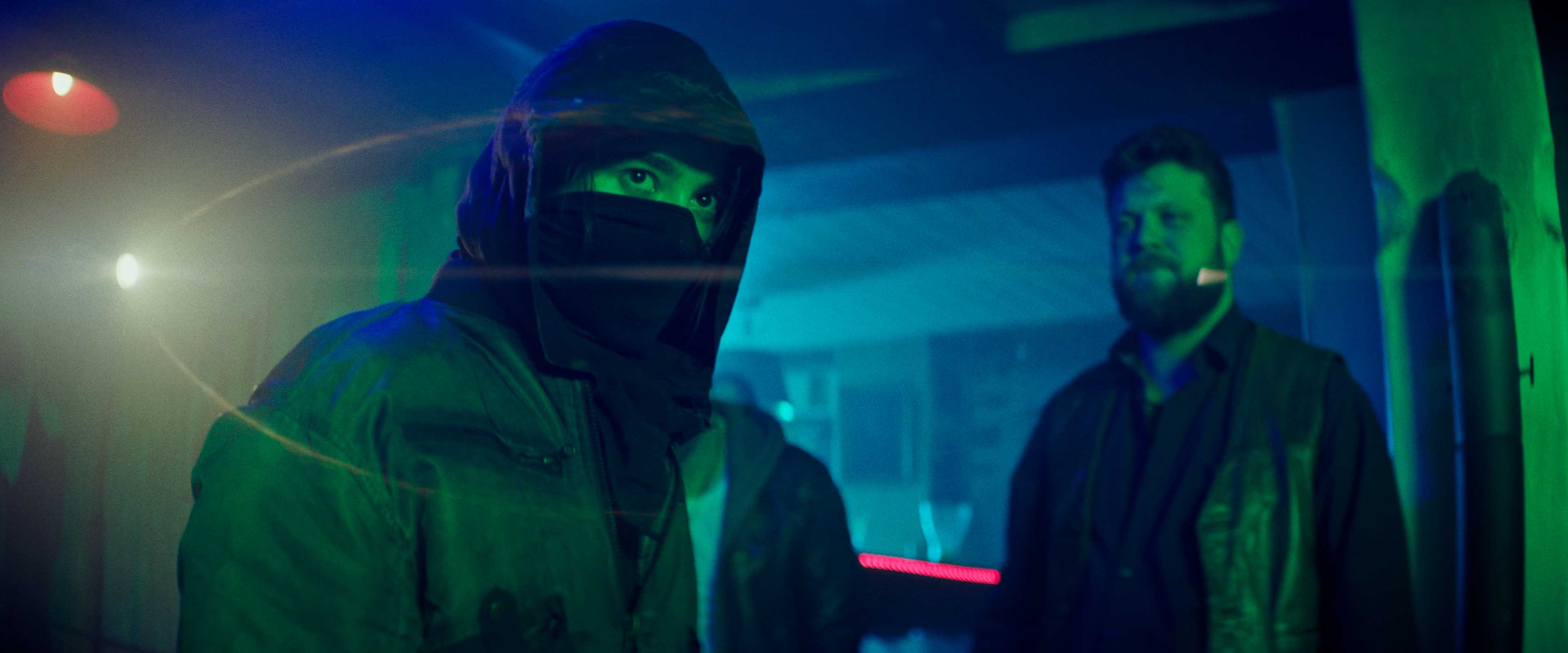 Close-up of a Porsche 911 GT3 rear wing and glowing LED taillight, bathed in deep red tunnel light.