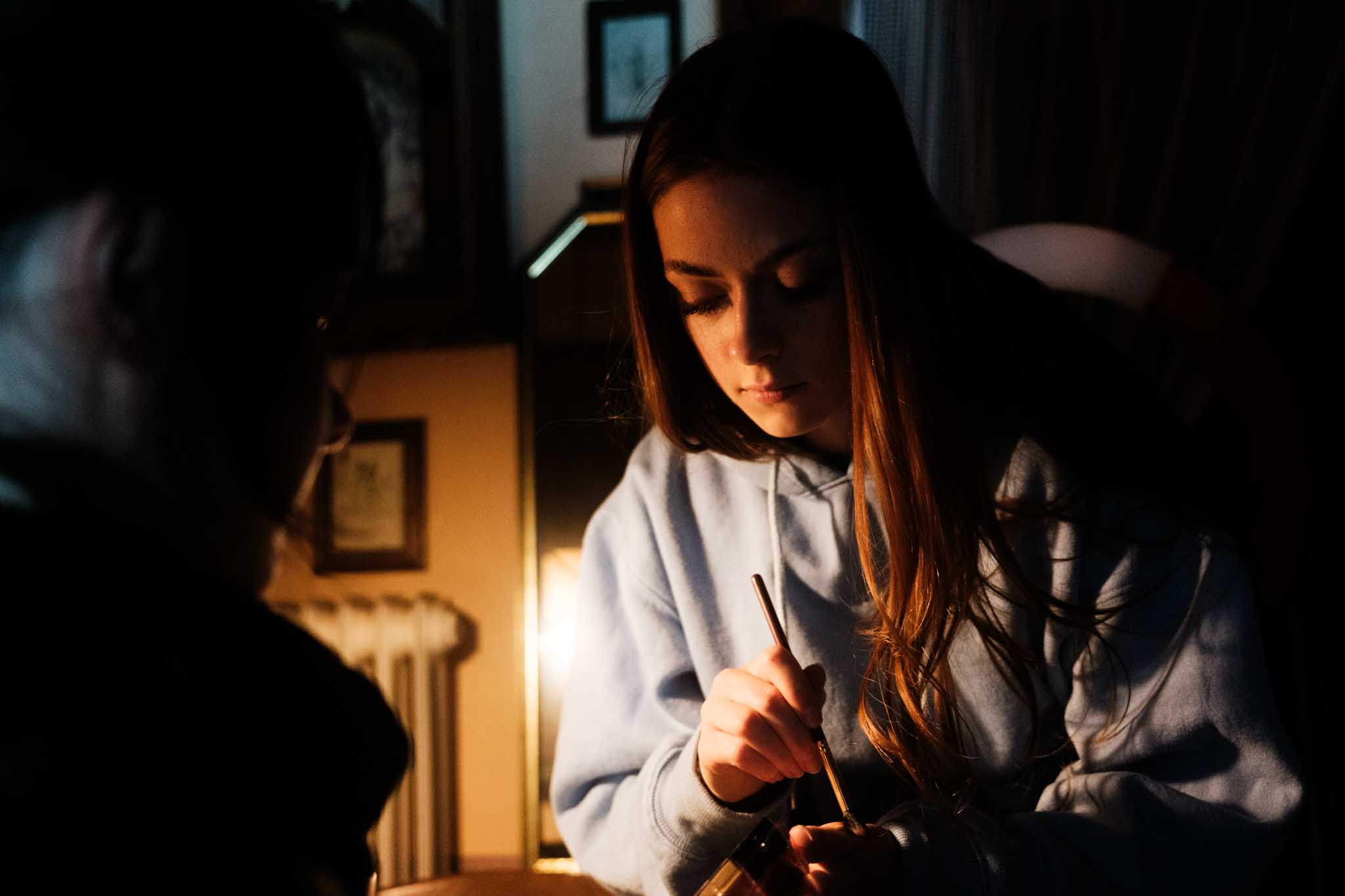 Silhouette of a helmeted racing driver at dusk, mountain skyline faintly visible under violet sky.