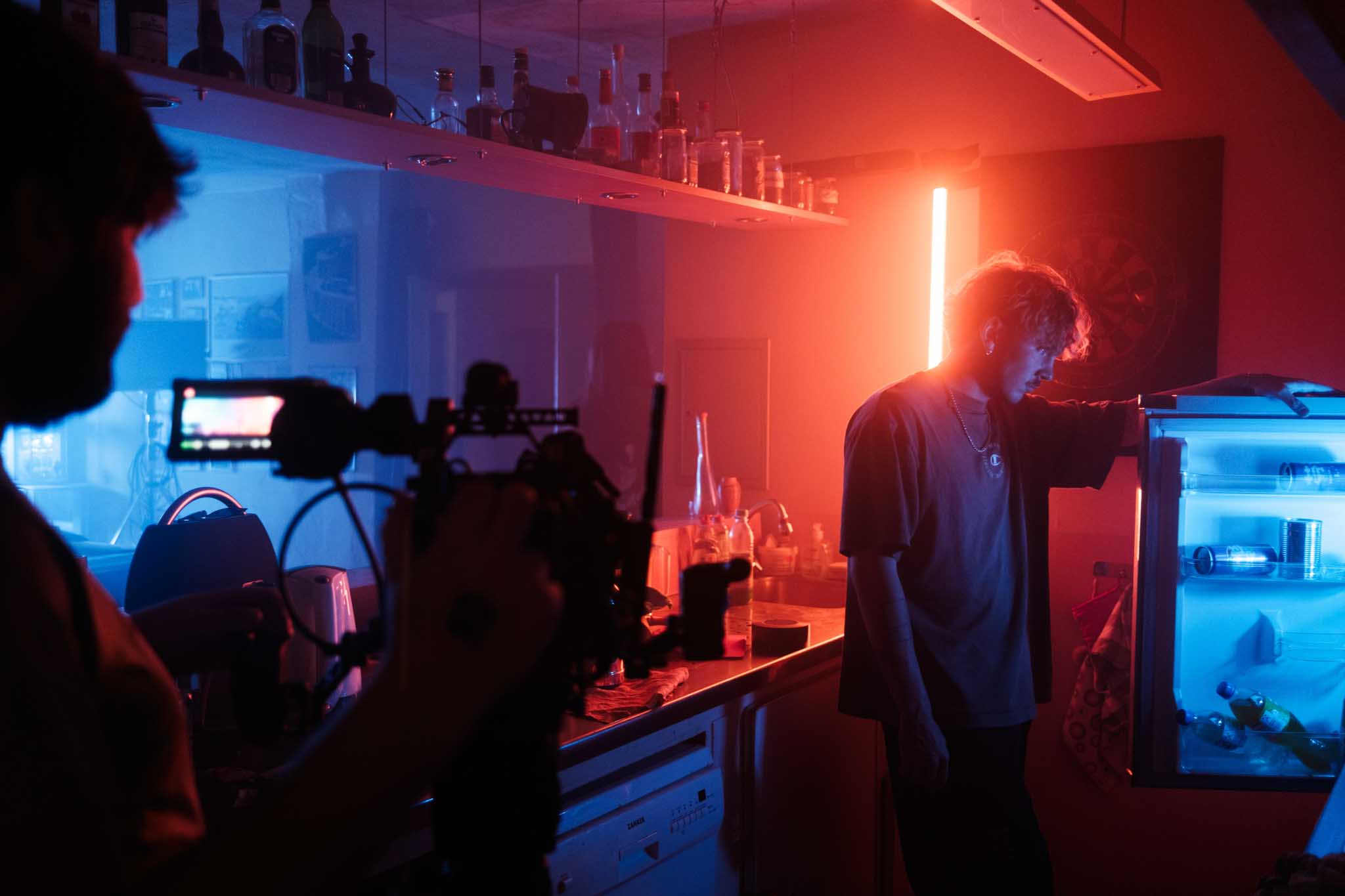 Close-up of a Porsche 911 GT3 rear wing and glowing LED taillight, bathed in deep red tunnel light.