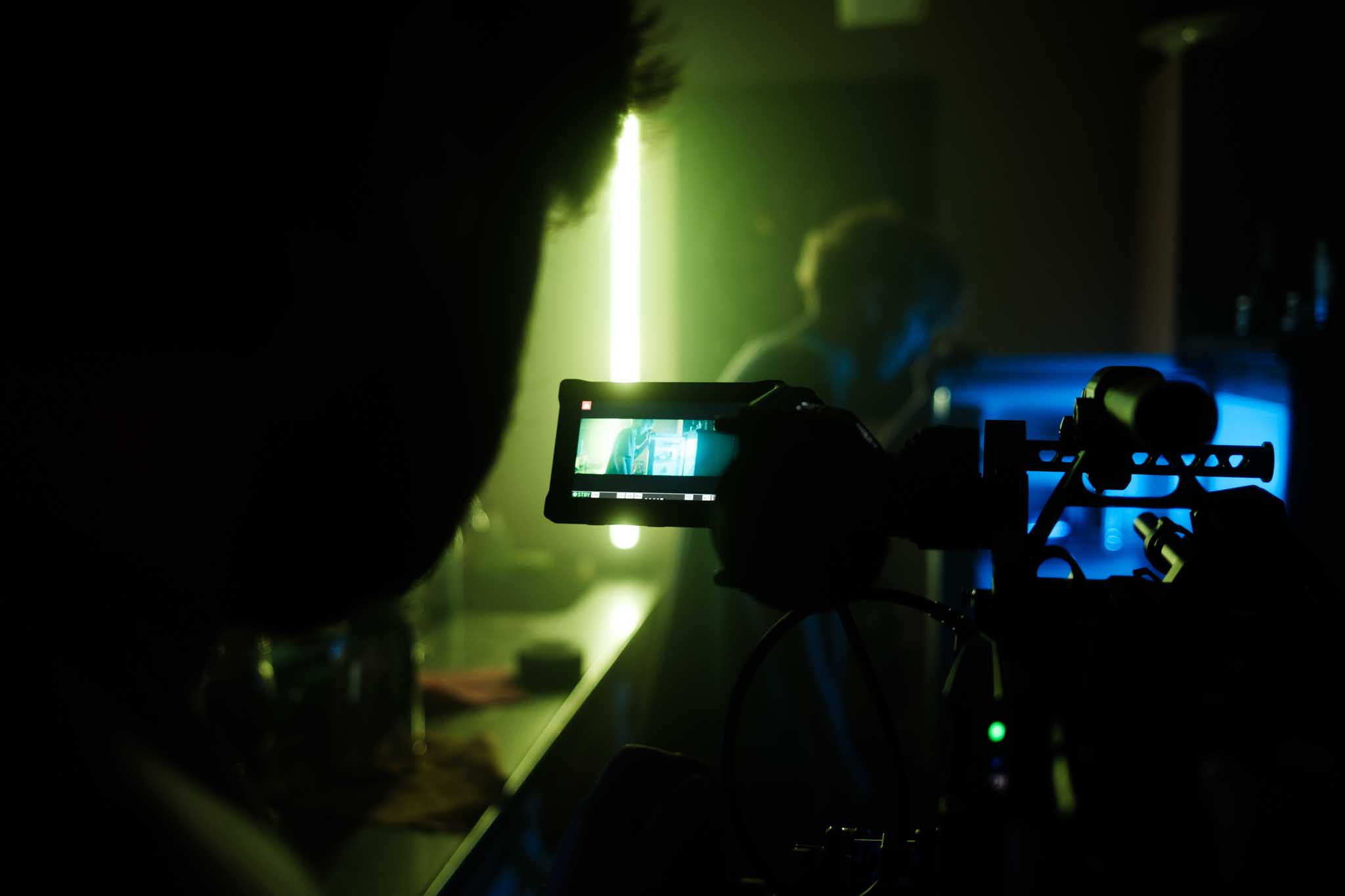 Aerial view of an alpine lakeside road with avalanche gallery; tiny sports car speeds along the shoreline.