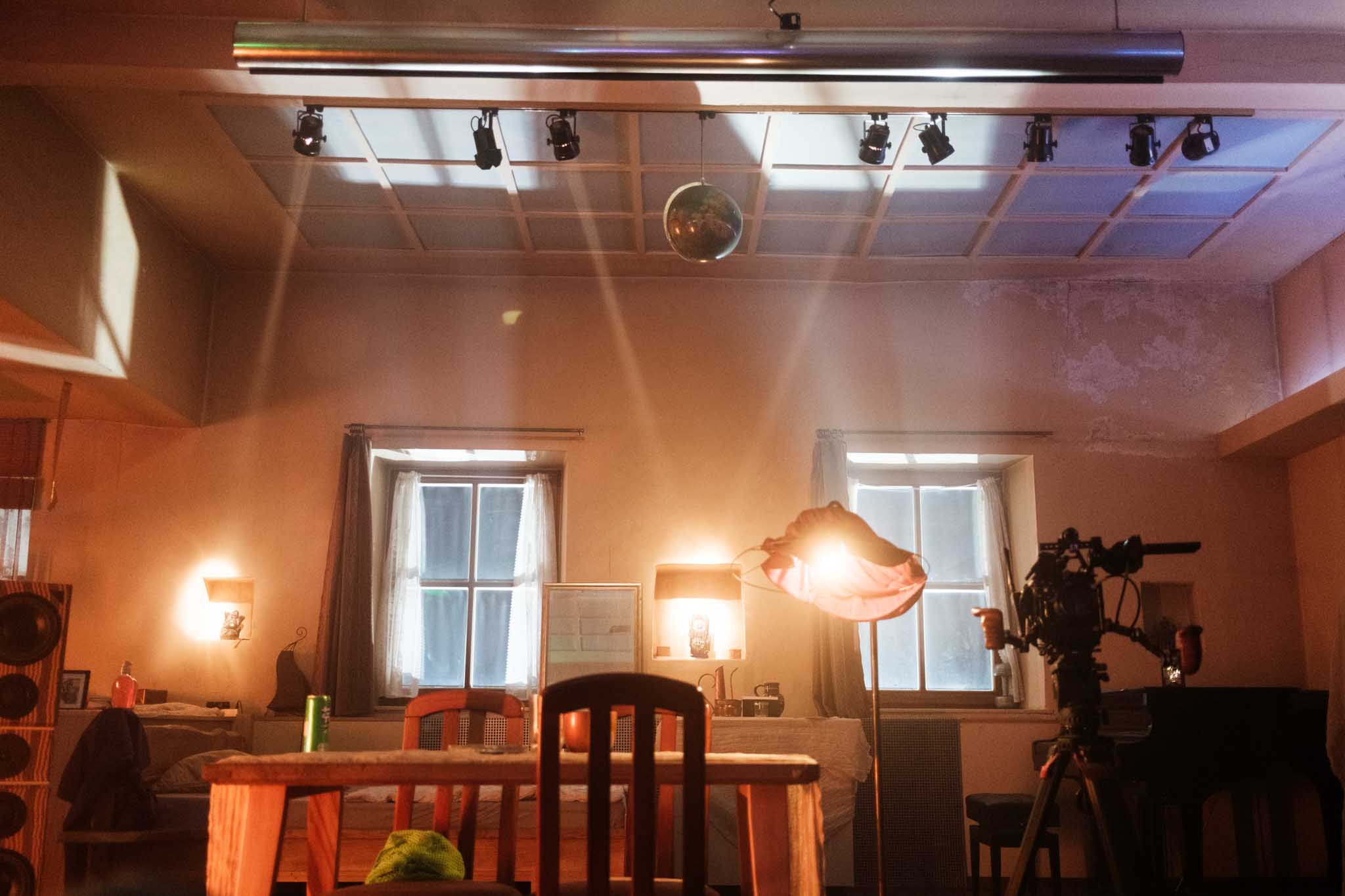 Silhouette of a helmeted racing driver at dusk, mountain skyline faintly visible under violet sky.