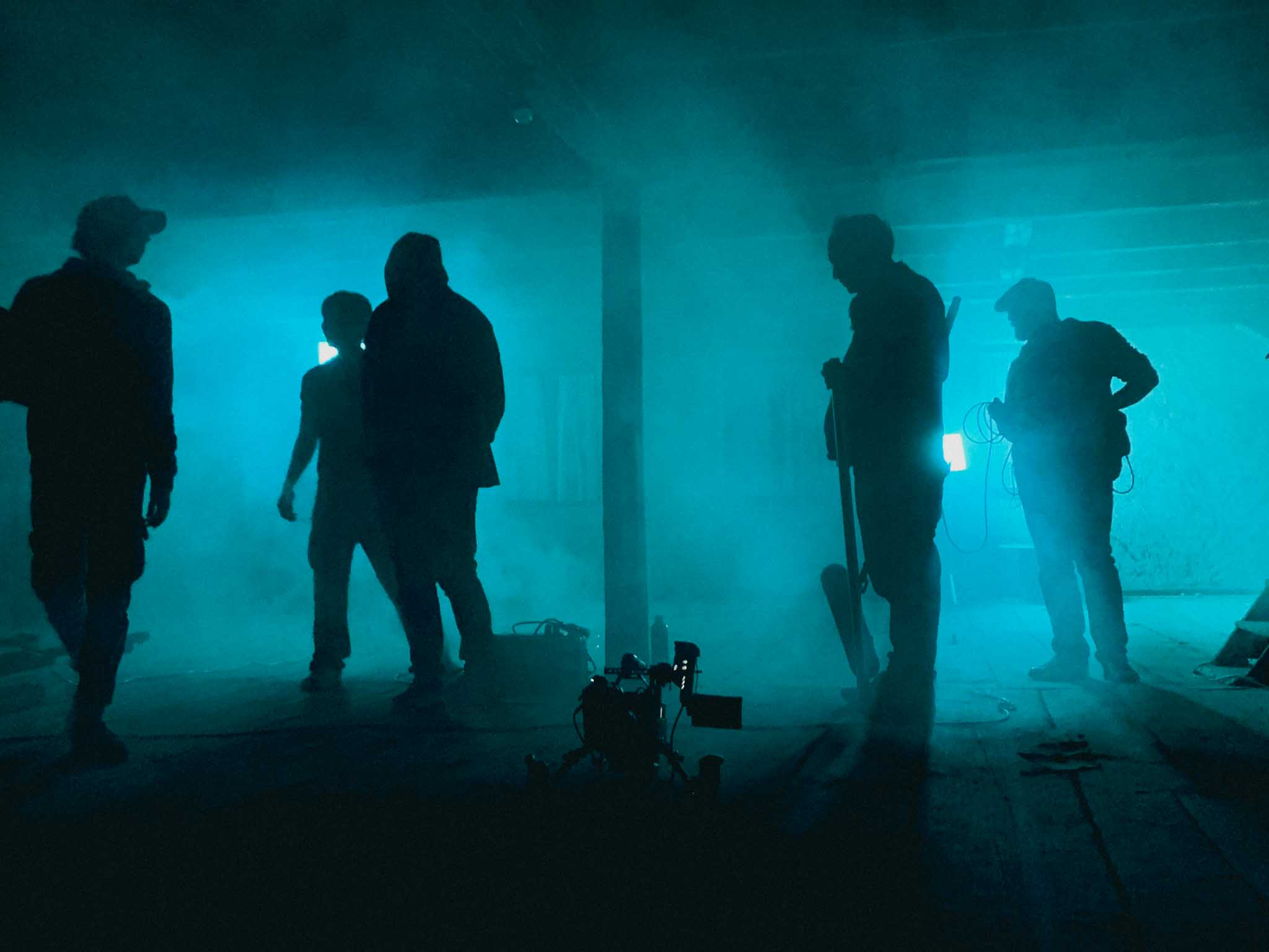 Silver Porsche 911 GT3 racing up a mountain road, motion-blurred asphalt and dramatic cloudscape in the background.
