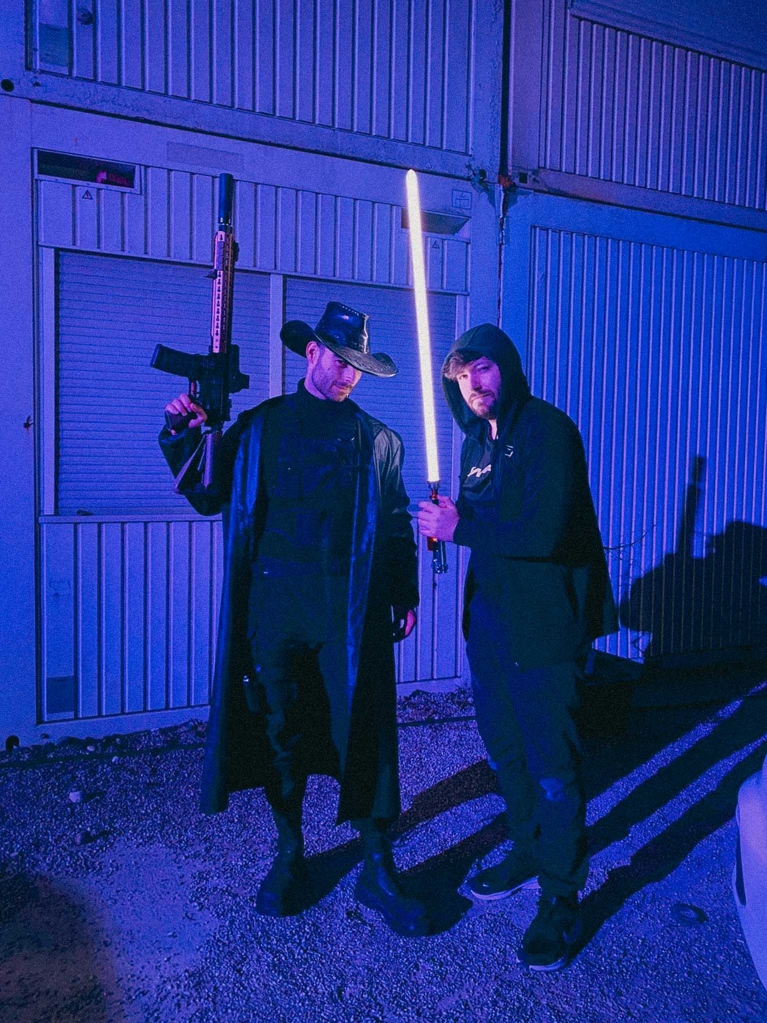 Aerial view of an alpine lakeside road with avalanche gallery; tiny sports car speeds along the shoreline.