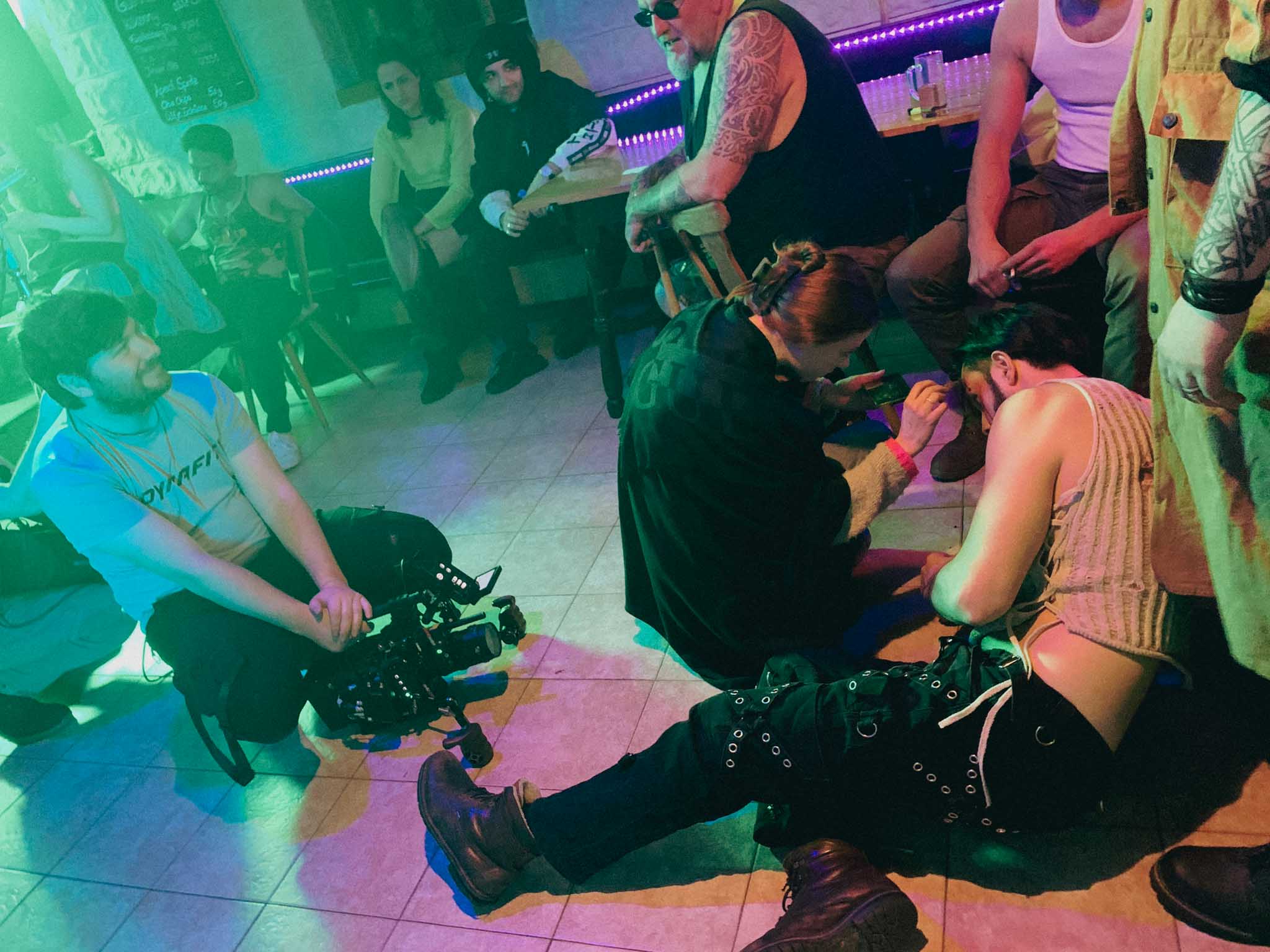 Silhouette of a helmeted racing driver at dusk, mountain skyline faintly visible under violet sky.