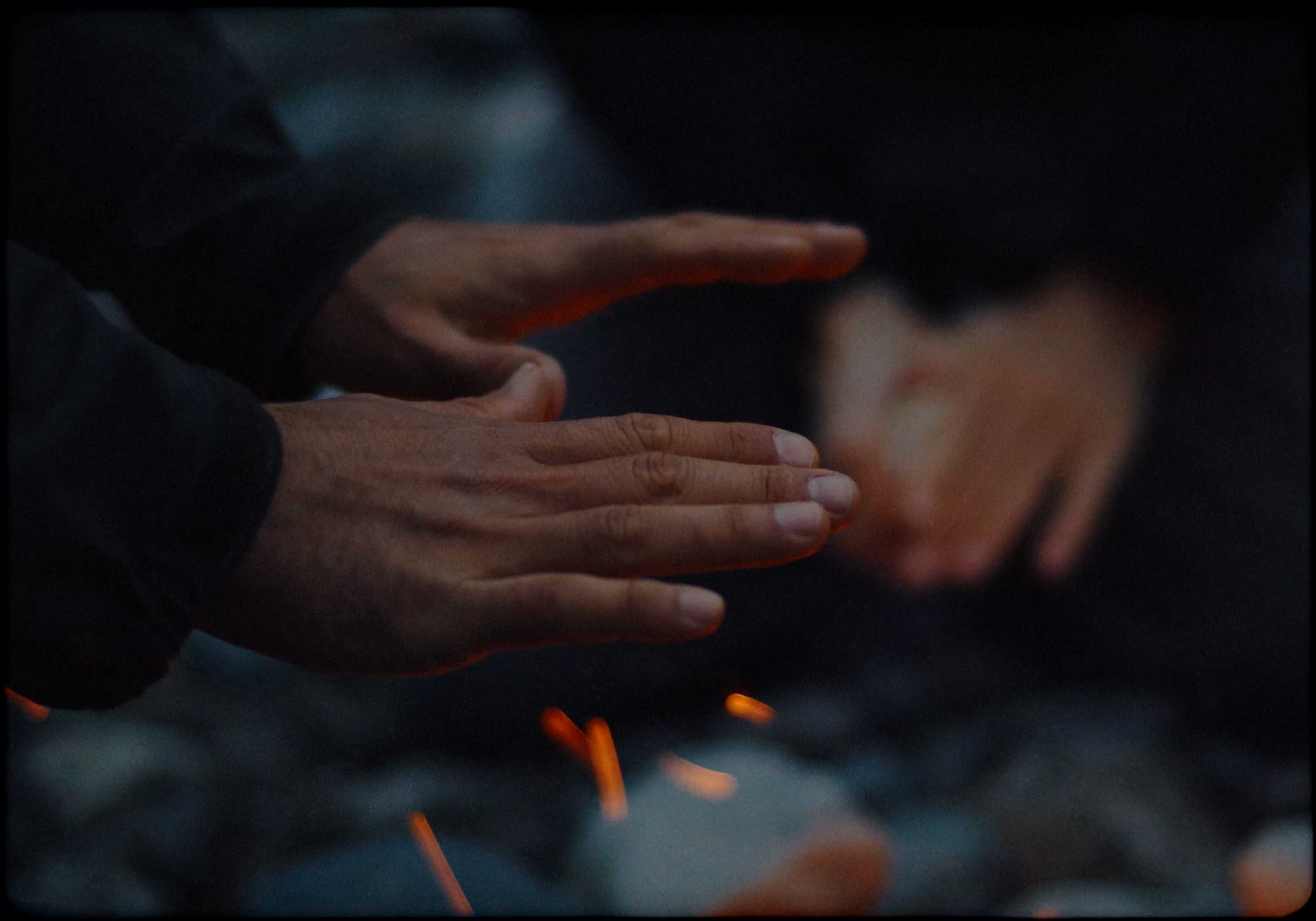 Aerial view of an alpine lakeside road with avalanche gallery; tiny sports car speeds along the shoreline.
