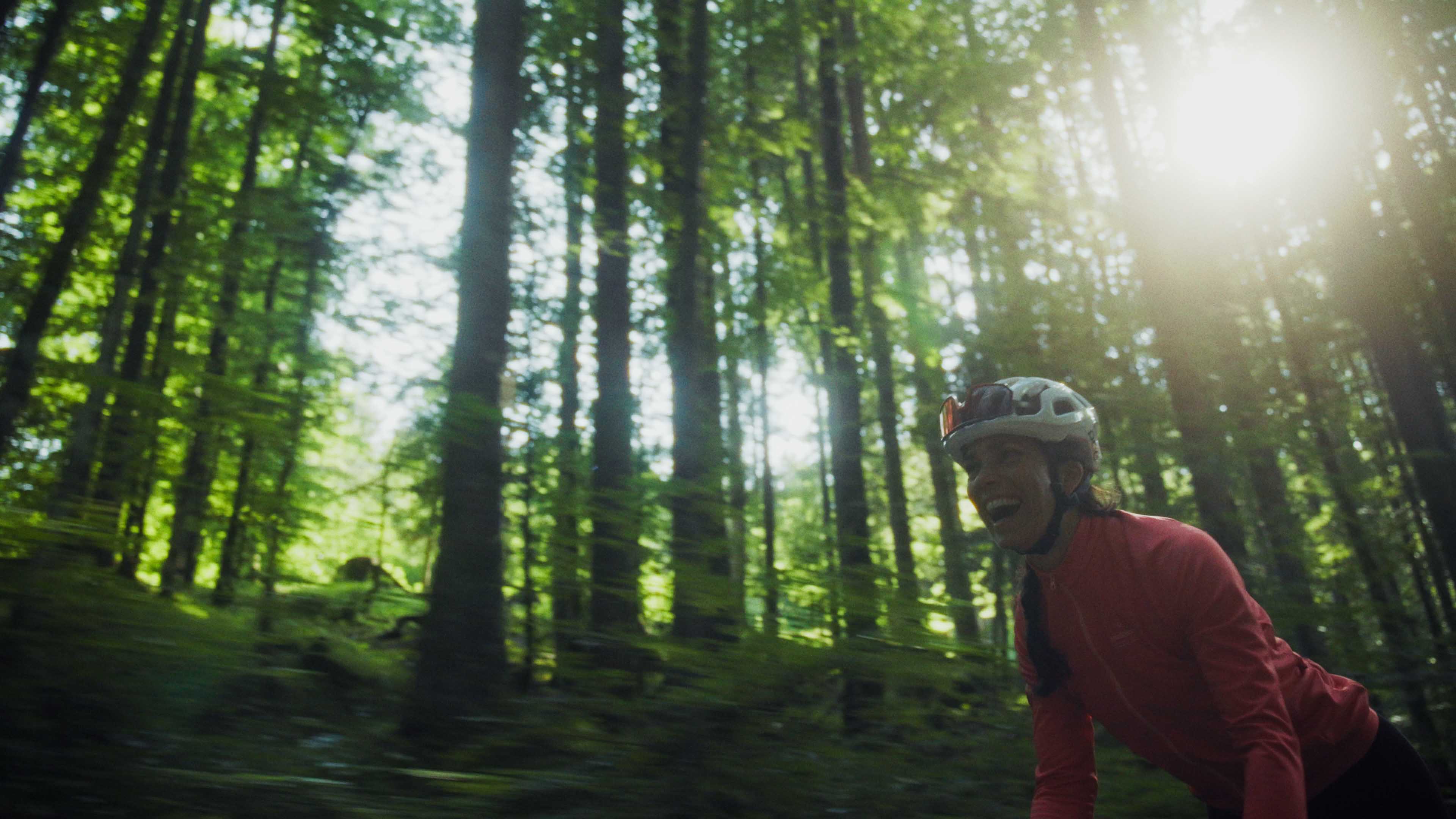 Rear view of a Porsche GT3 entering a foggy racetrack curve at dawn, headlights piercing the mist.
