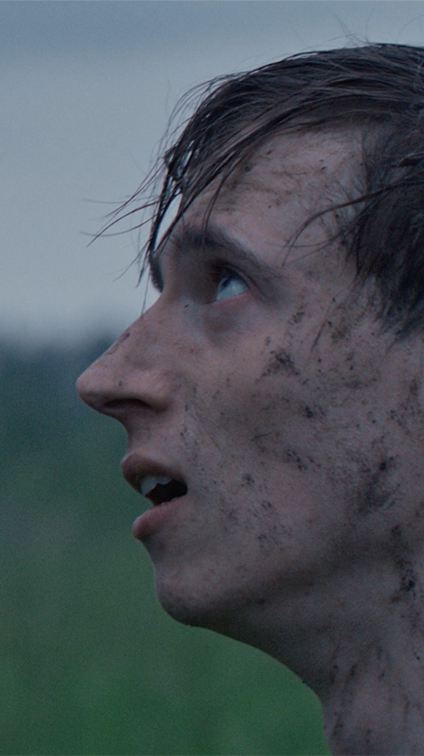 Close up profile of a man looking up, face slightly dirty